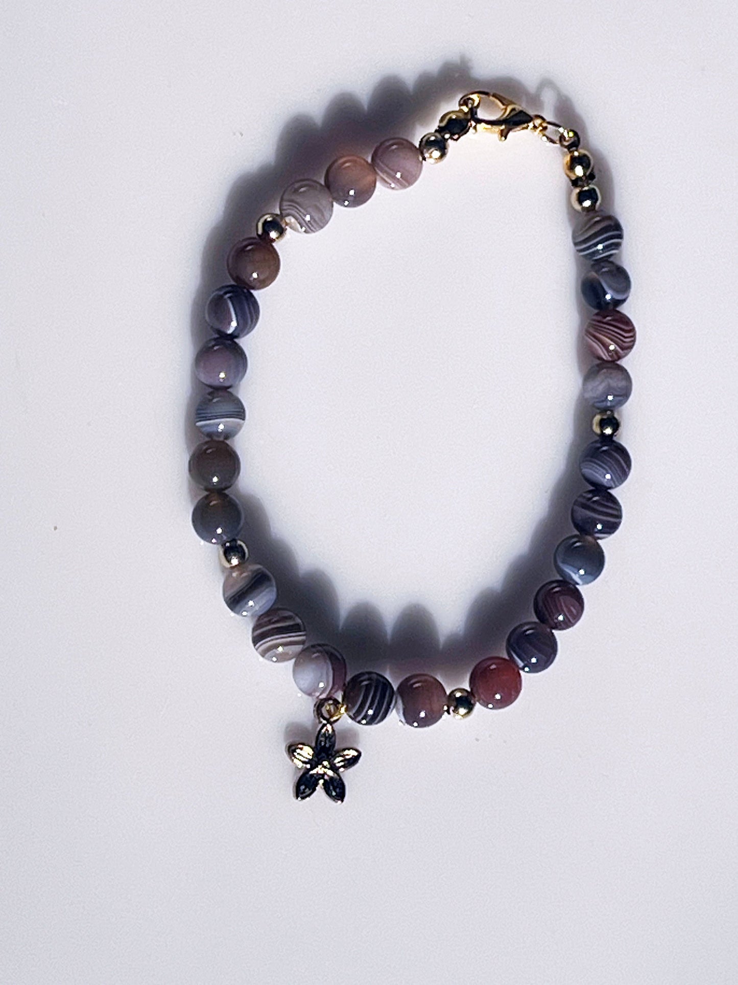 Botswana Gemstone Bracelet - Brown Botswana beaded bracelet with golden spacers and hanging flower golden charm.