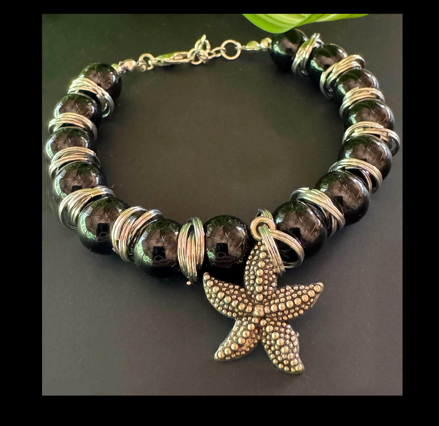 Handmade 10mm Black Onyx with Sea Star Charm Gemstone Bracelet - Strength & Serenity. Black Onyx Gemstone bracelet with silver spacers and hanging Seastar charm.