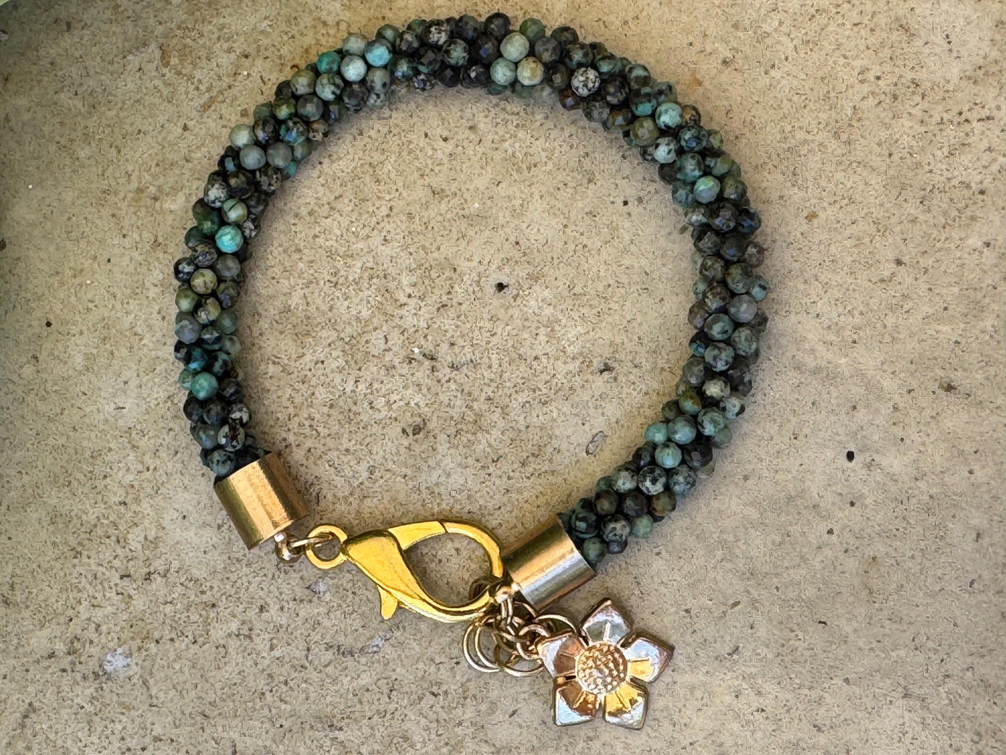 Kumihimo African Turquoise Gemstone Bracelet - African Turquoise Gemstone bracelet with golden flower hanging charm.