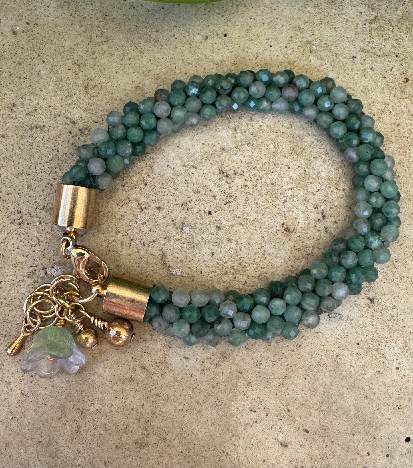 Kumihimo Emerald Gemstone Bracelet - Emerald Gemstone bracelet with golden flower hanging charm.